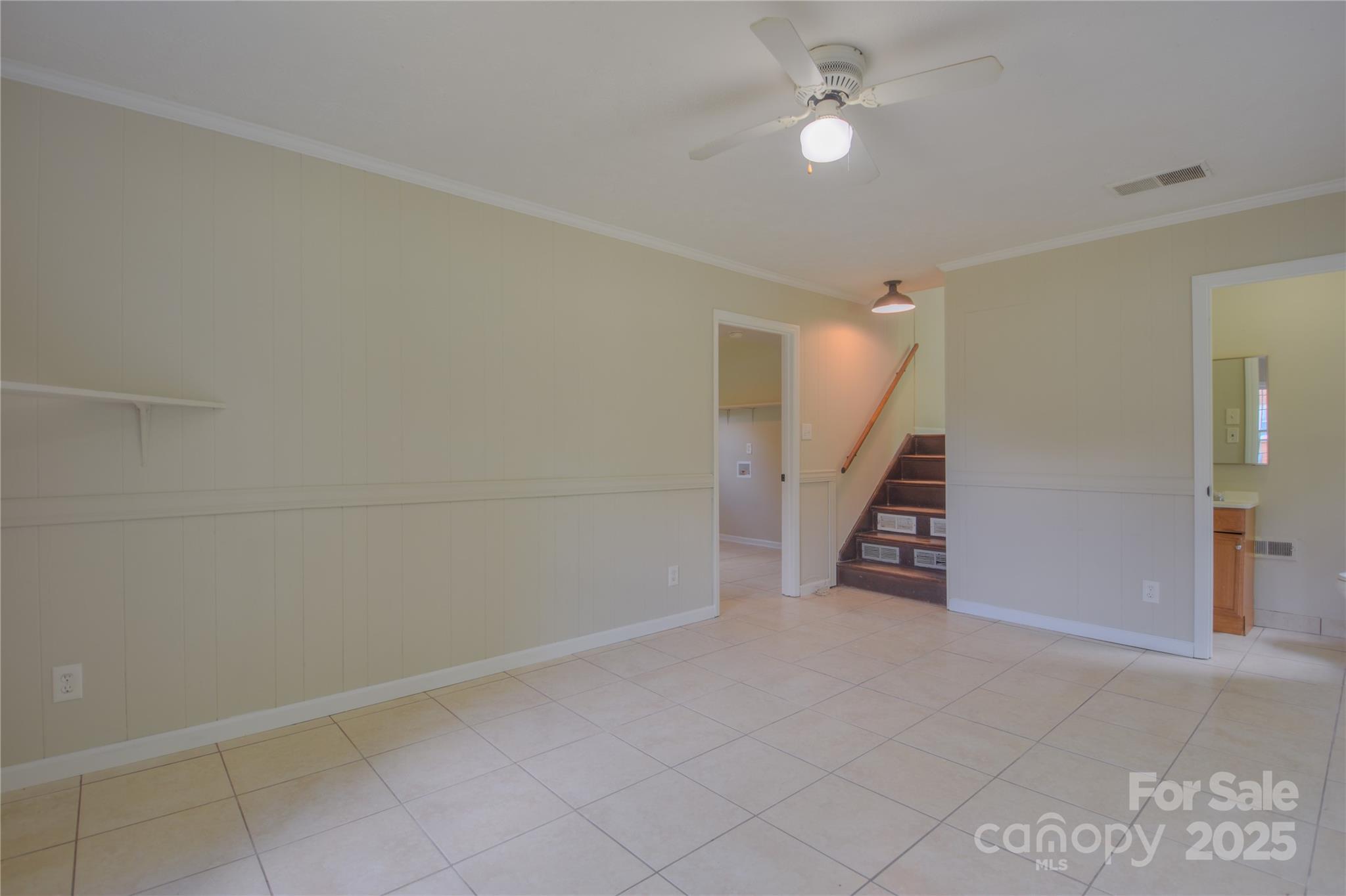 6921 Idlewild Road Charlotte, NC 28212 - Photo 18 of 29 an empty room with stairs and fan