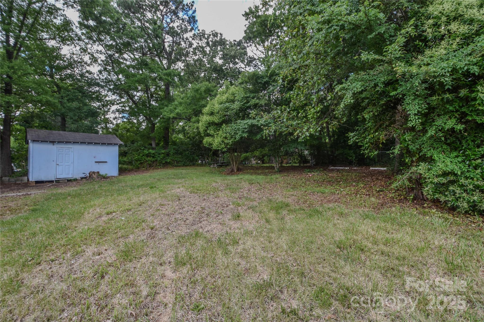 6921 Idlewild Road Charlotte, NC 28212 - Photo 28 of 29 a view of a backyard with a barn and large trees