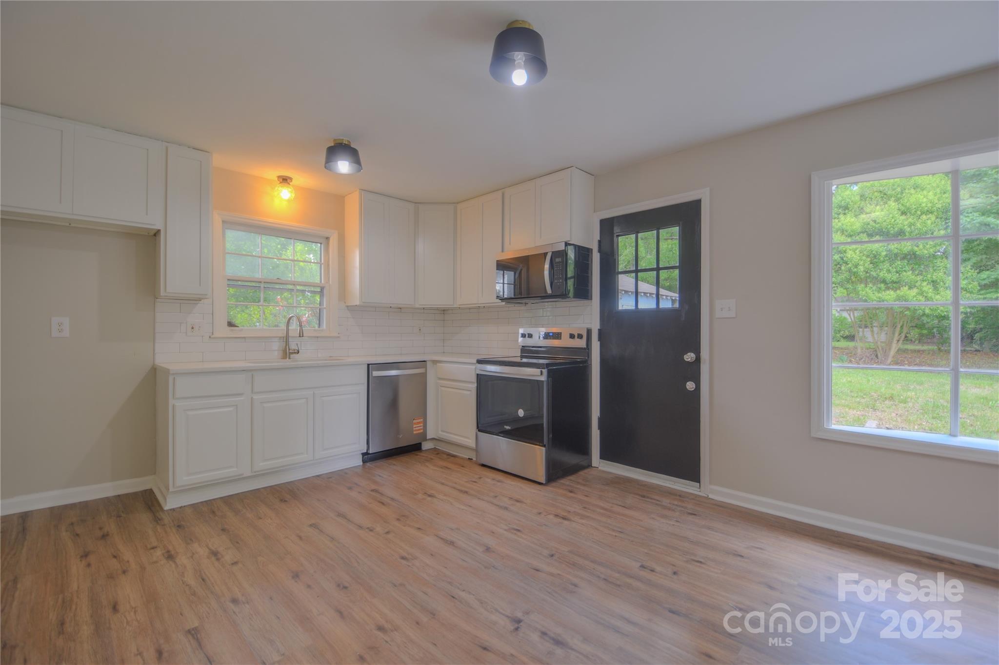6921 Idlewild Road Charlotte, NC 28212 - Photo 8 of 29 a kitchen with a refrigerator and a stove top oven