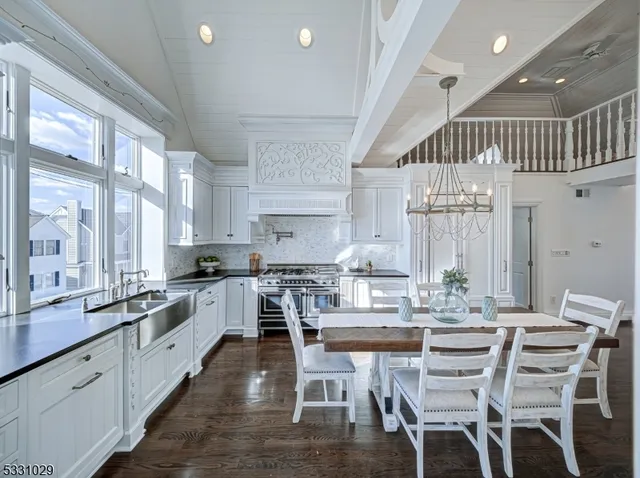 a kitchen with white cabinets and wooden floor