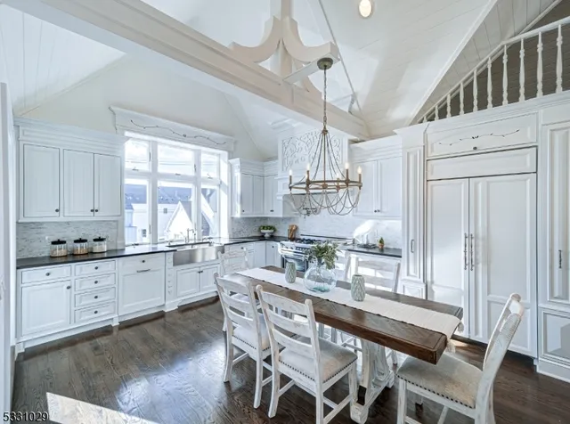 a dining table with wooden floor and kitchen view