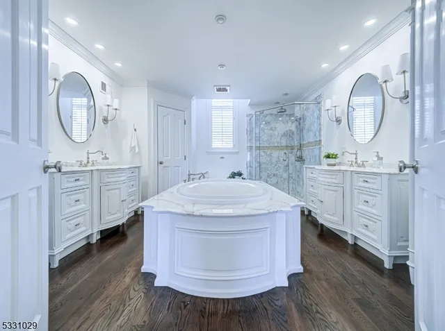 a spacious bathroom with a tub mirror and toilet