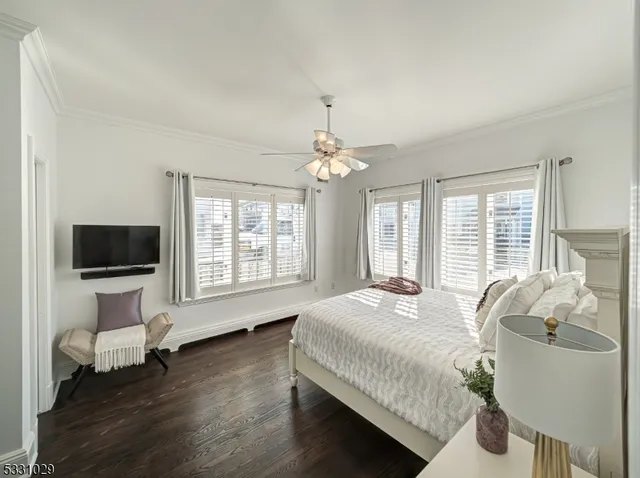 a spacious bedroom with a bed and a flat screen tv