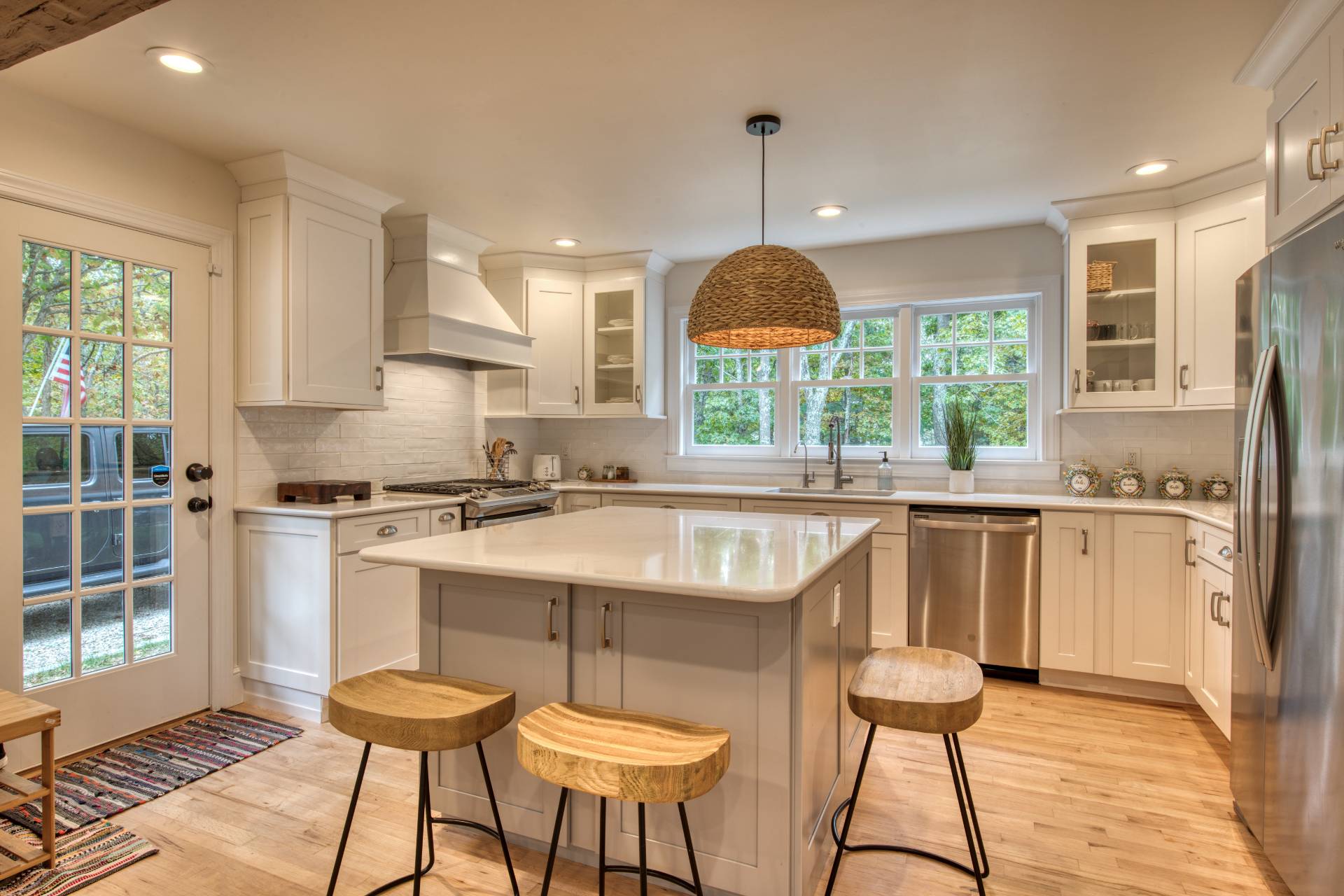 8 Grape Arbor Lane East Hampton, NY 11937 - Photo 5 of 15 a kitchen with stainless steel appliances a sink a stove a refrigerator cabinets and a dining table with wooden floor