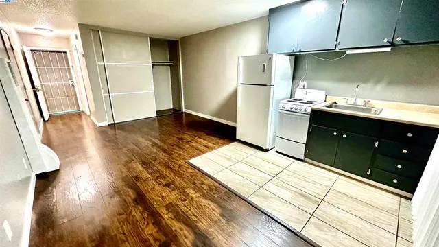 a kitchen with a refrigerator and a stove top oven