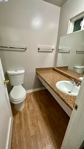 a bathroom with a granite countertop toilet sink and mirror
