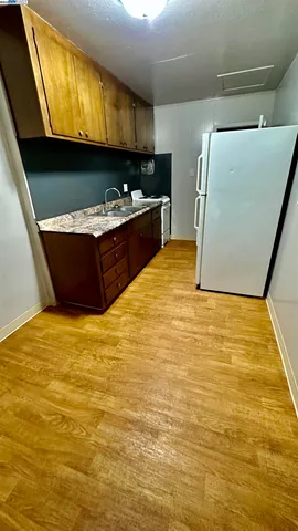 a room with stainless steel appliances wooden cabinets and front door