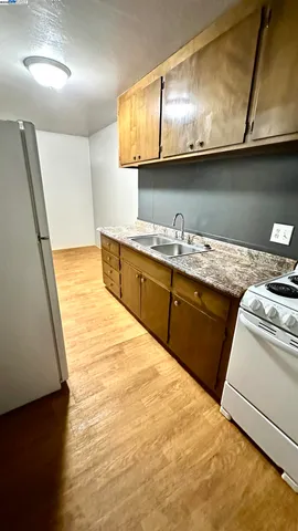a kitchen with granite countertop a sink a stove and cabinets