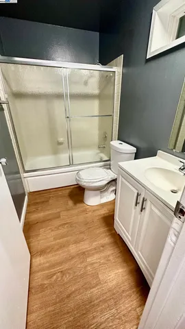 a bathroom with a granite countertop sink toilet and a mirror