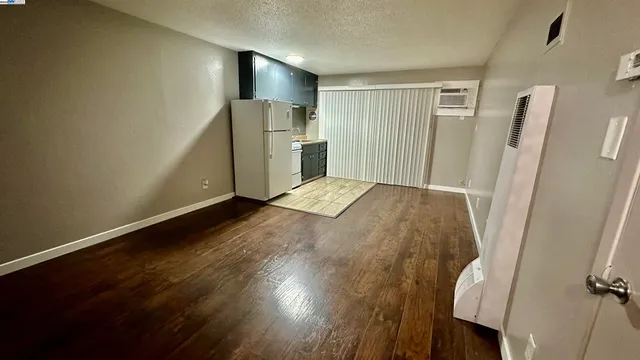 a view of empty room with wooden floor and window