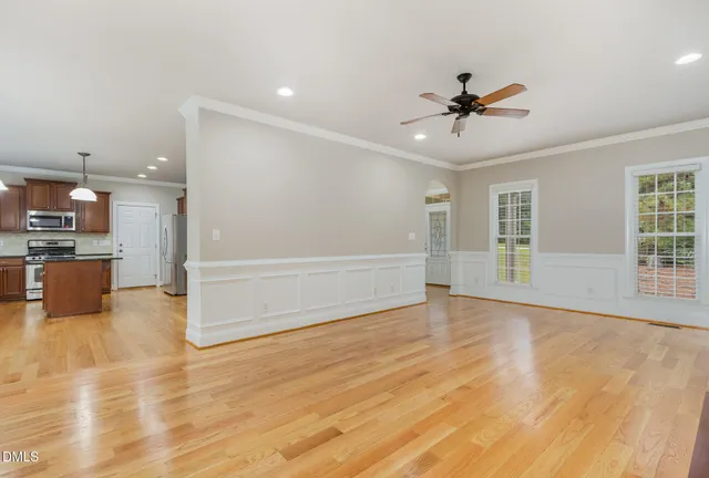 a large kitchen with stainless steel appliances kitchen island granite countertop a large cabinets a sink and a chandelier