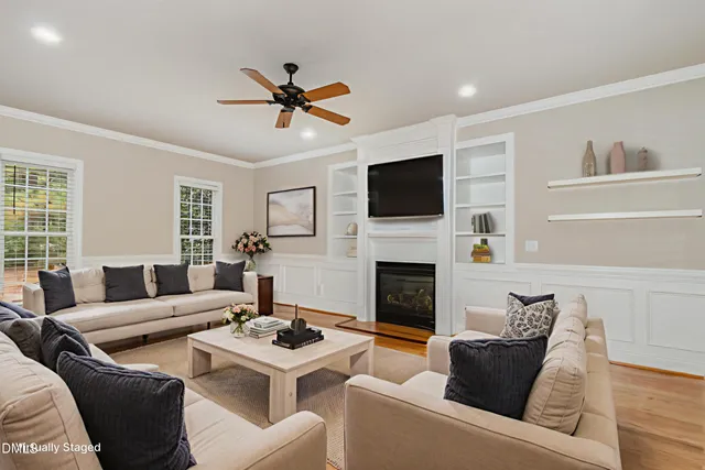 a kitchen with stainless steel appliances granite countertop a stove top oven a sink dishwasher a refrigerator and a dining table with wooden floor