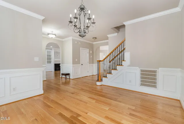 an empty room with chandelier fan