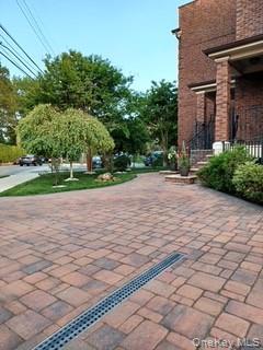 127-22 Kew Gardens Road Queens, NY 11415 - Photo 4 of 21 a sidewalk with a building and trees in the background