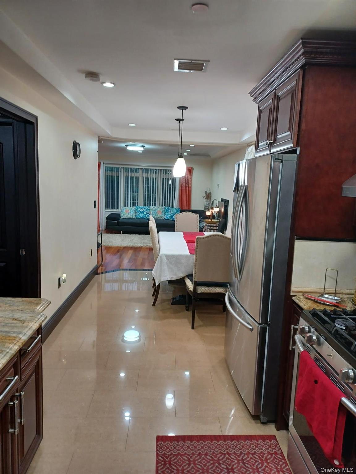 127-22 Kew Gardens Road Queens, NY 11415 - Photo 8 of 21 a living room with furniture and a refrigerator
