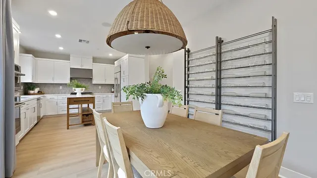 a kitchen with a refrigerator and white wooden cabinets
