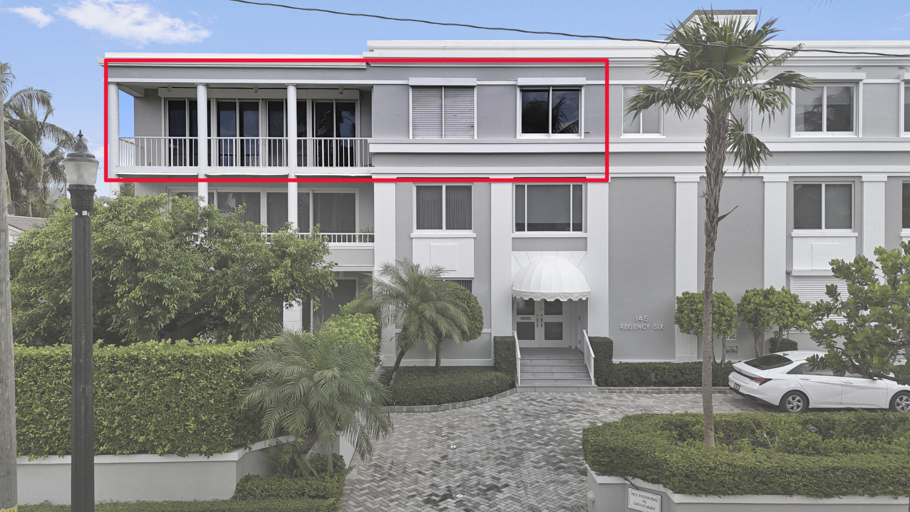 145 Peruvian Avenue, Unit 301 Palm Beach, FL 33480 - Photo 3 of 16 a view of a white house with large windows and a yard with plants