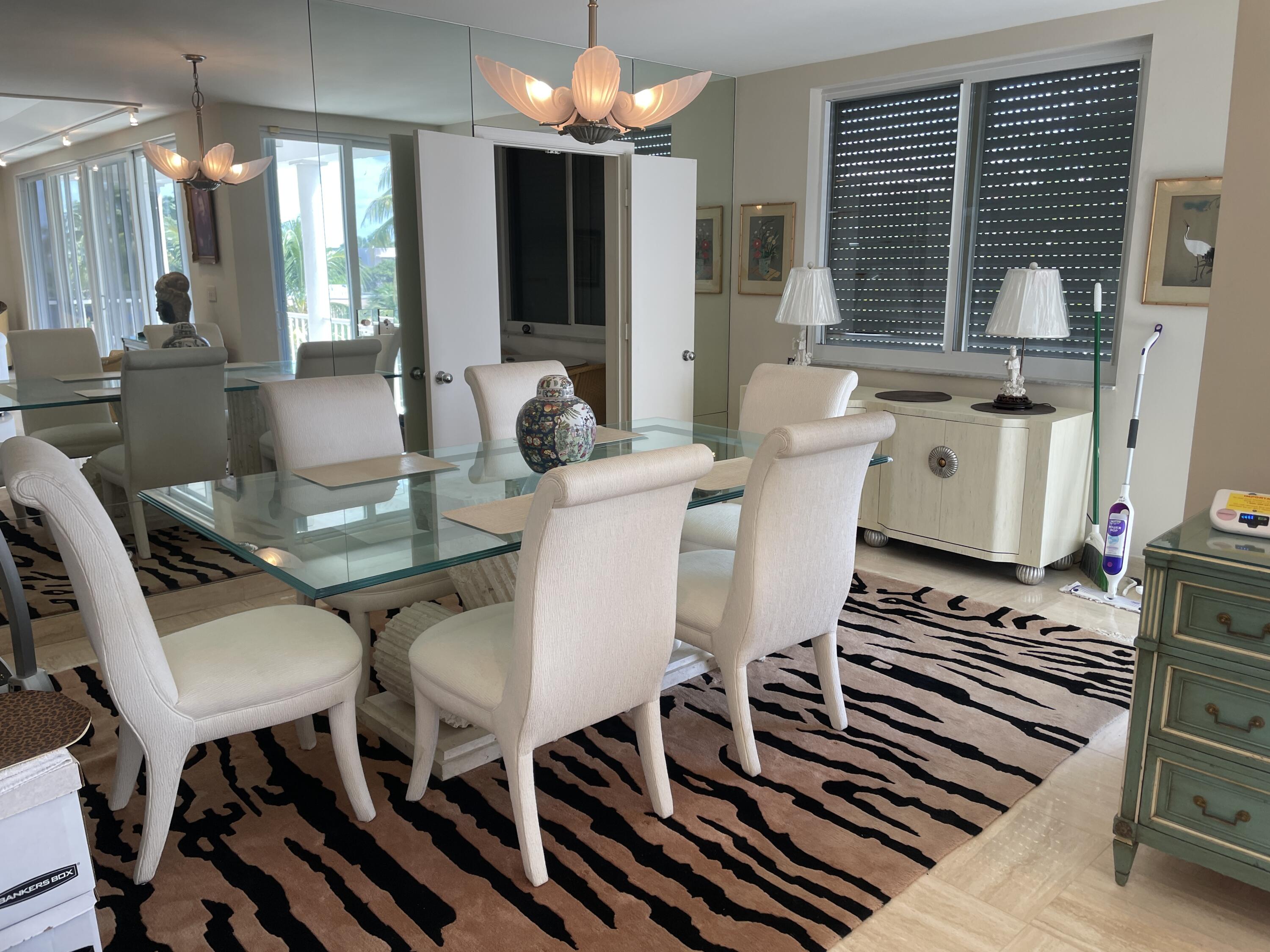 145 Peruvian Avenue, Unit 301 Palm Beach, FL 33480 - Photo 7 of 16 a view of a dining room with furniture a chandelier and large windows