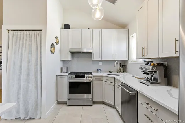 a kitchen with stainless steel appliances granite countertop a sink a stove and cabinets