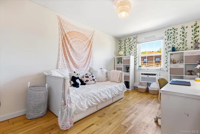 a bedroom with a bed wooden floor and window