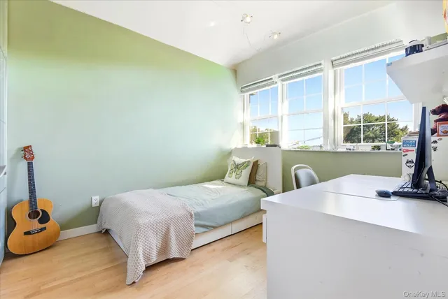 a bedroom with a bed and large windows