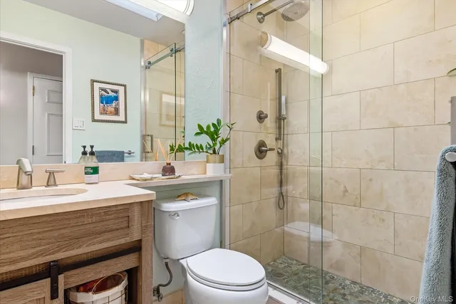 a bathroom with a sink a toilet and shower