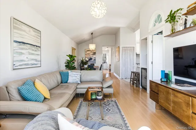 a living room with furniture flat screen tv and a large window