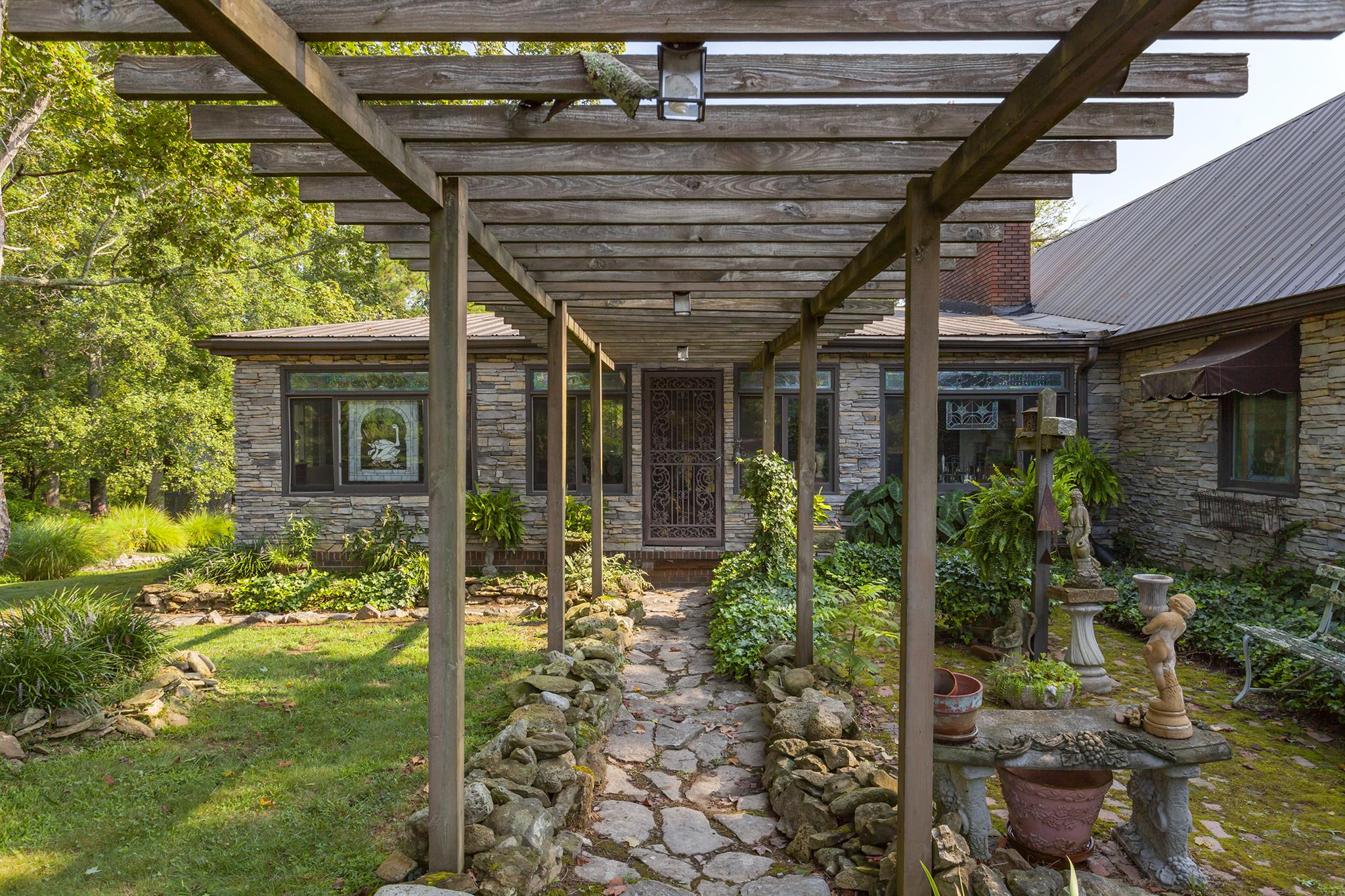 1635 Camp Ravine Road Burns, TN 37029 - Photo 1 of 28 a porch with a table and chairs and potted plants