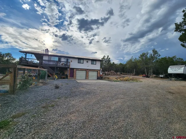 a view of a house with a yard and sitting area
