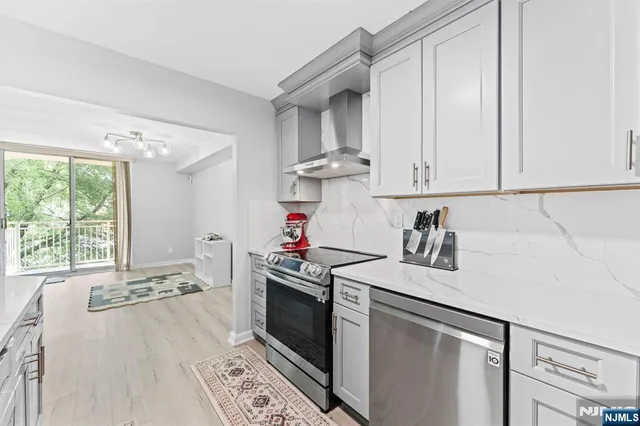 a kitchen with stainless steel appliances granite countertop a sink stove and white cabinets