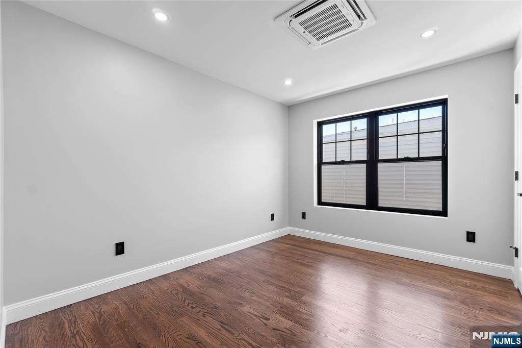 481 15th Avenue Newark, NJ 07103 - Photo 12 of 19 an empty room with wooden floor and windows