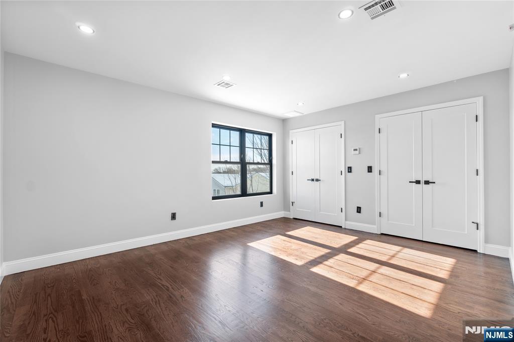 481 15th Avenue Newark, NJ 07103 - Photo 15 of 19 an empty room with wooden floor and windows