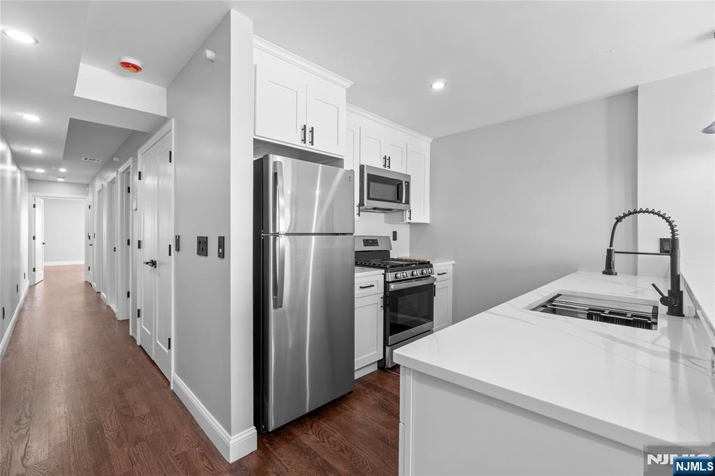 481 15th Avenue Newark, NJ 07103 - Photo 5 of 19 a kitchen with a refrigerator sink and cabinets