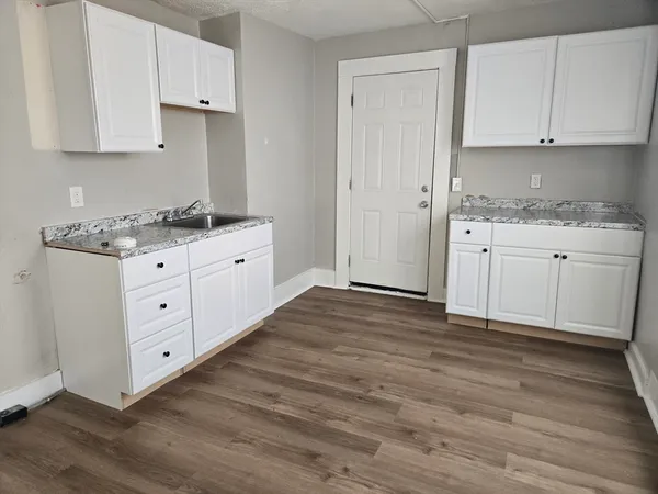 a kitchen with granite countertop white cabinets and white appliances