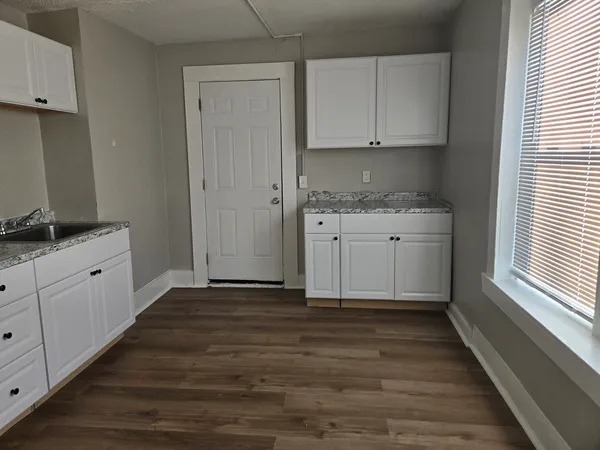 a kitchen with granite countertop white cabinets and white appliances
