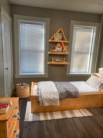 a bedroom with a bed and wooden floor