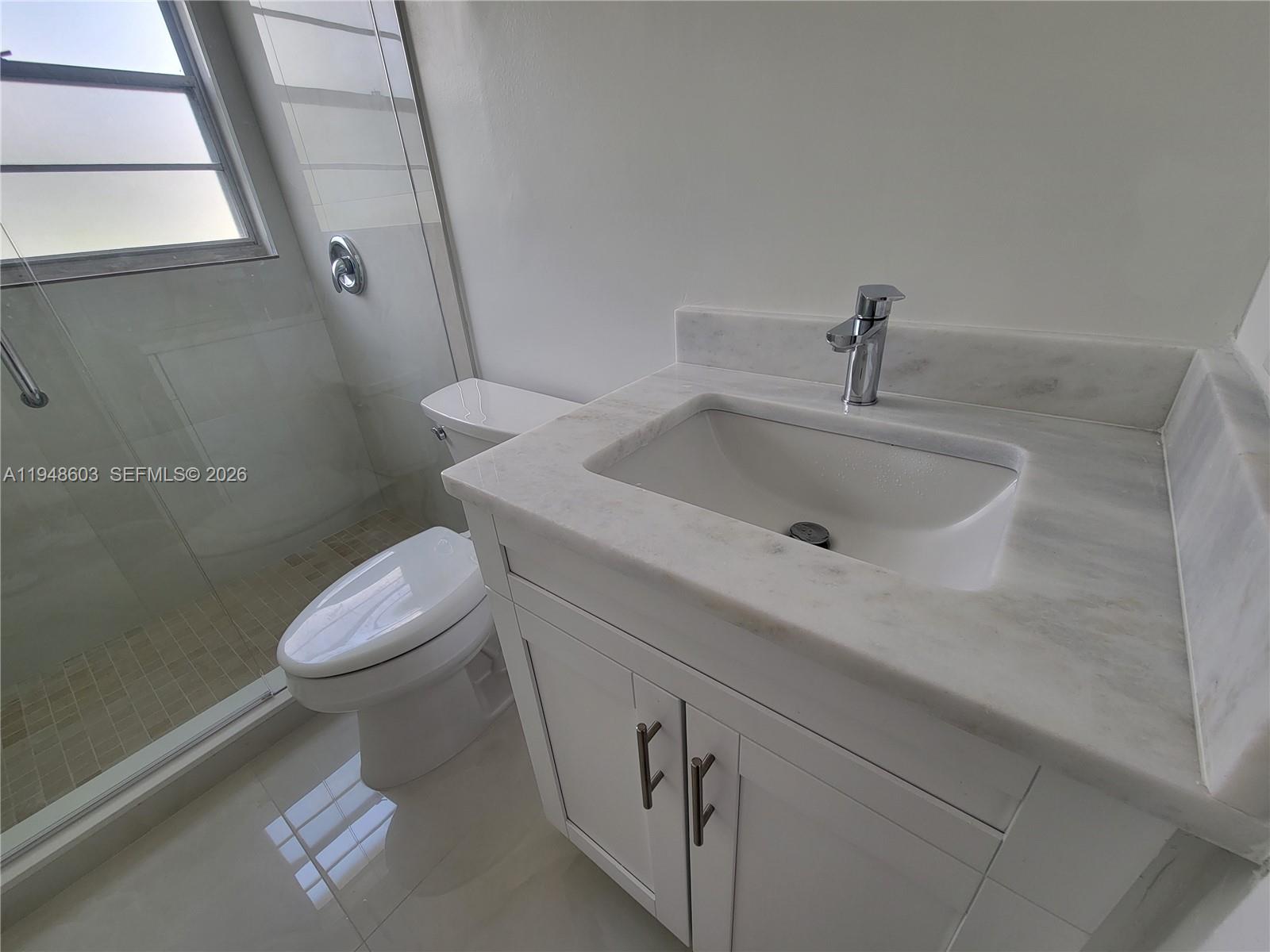 196 Mansfield F, Unit 196 Boca Raton, FL 33434 - Photo 17 of 58 a bathroom with a sink and a toilet