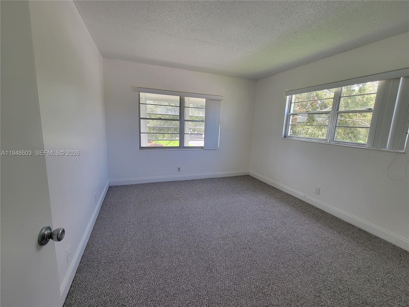 196 Mansfield F, Unit 196 Boca Raton, FL 33434 - Photo 37 of 58 an empty room with windows