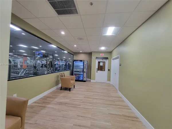 a view of a car in back of a building with lot of cars parked