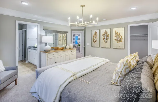 a spacious bedroom with a large bed and a chandelier