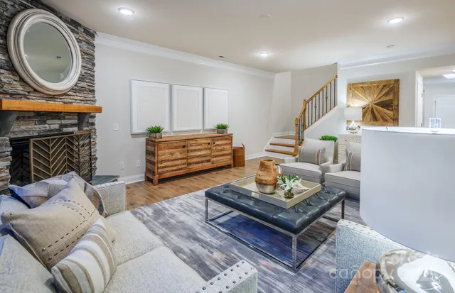 a living room with furniture a fireplace a window and a potted plant