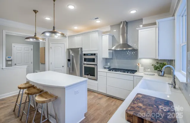 a kitchen with kitchen island a stove a table and chairs in it