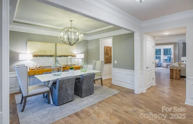 a view of a dining room with furniture a chandelier and wooden floor