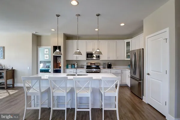 a kitchen with stainless steel appliances granite countertop a refrigerator and a stove top oven