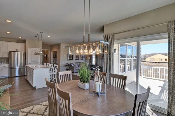 a dining room with furniture a chandelier and wooden floor
