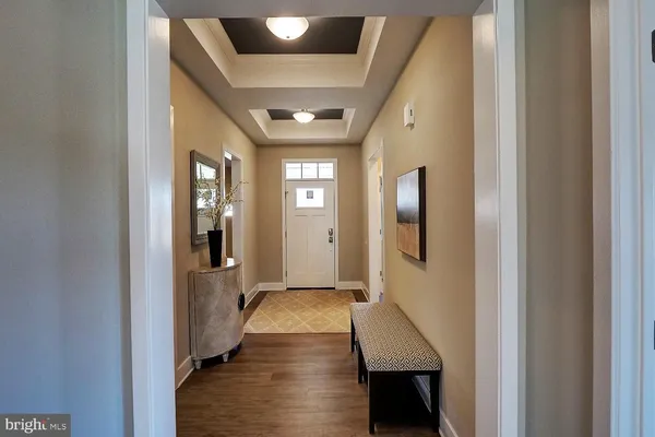 a hallway with wooden floor windows and livingroom
