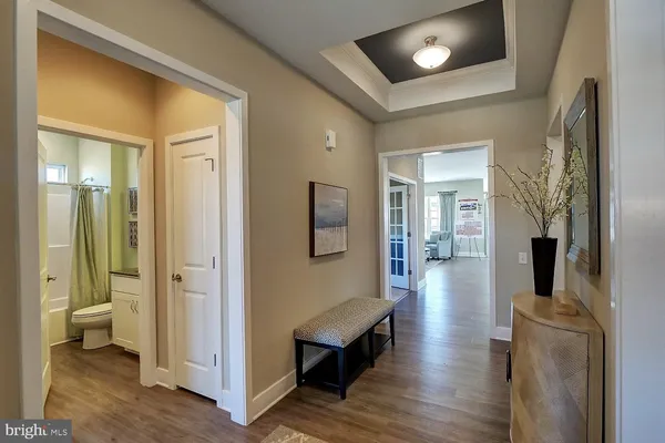 a view of a hallway with wooden floor and living room