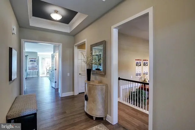 a view of a hallway with wooden floor and a living room