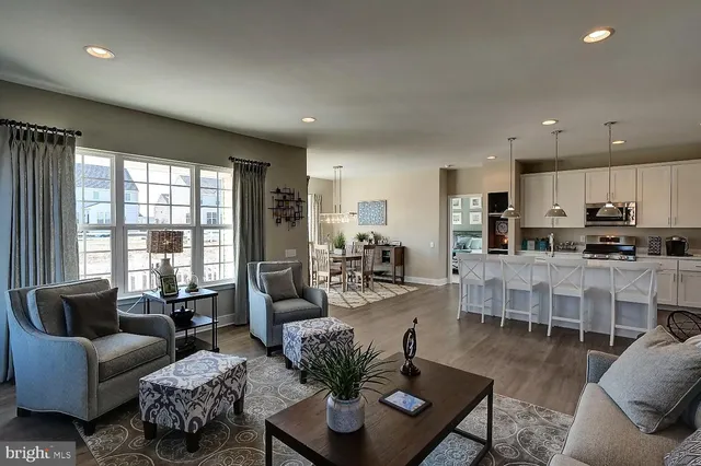 a living room with furniture kitchen and a large window