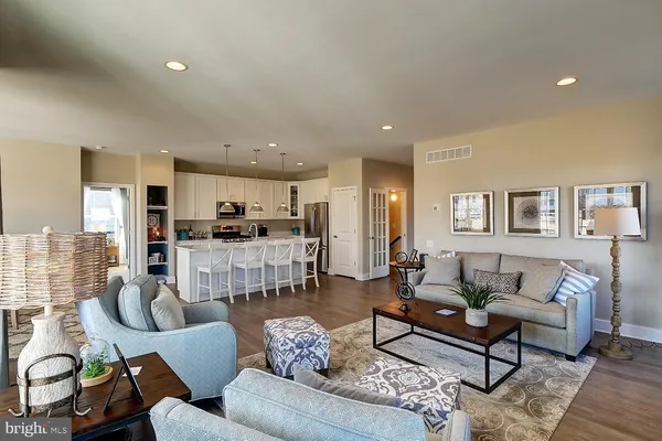 a living room with furniture and a view of kitchen